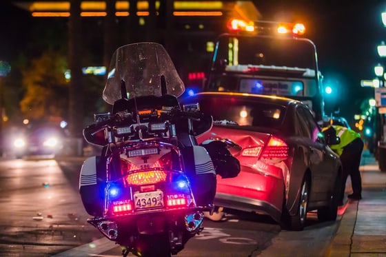 Police motorcycle and tow truck at a nighttime roadway collision