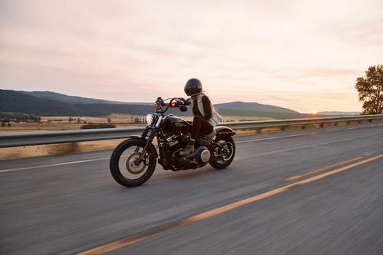 Motorcyclist riding on an open highway at sunset